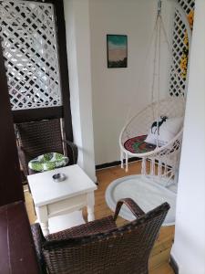 una habitación con 2 sillas y un columpio en Lazzy inn en Yangshuo