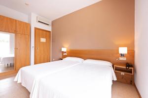 A bed or beds in a room at HOTEL LA PERLA