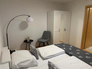 a hotel room with two beds and a chair at Alpenapart Seefeld in Seefeld in Tirol