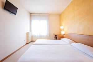 A bed or beds in a room at HOTEL LA PERLA