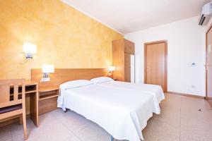 A bed or beds in a room at HOTEL LA PERLA Még 28 kép