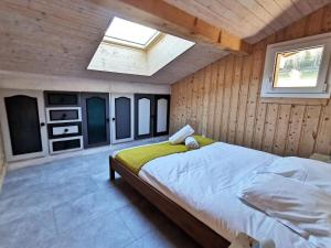 Schlafzimmer mit einem großen Bett und einem Dachfenster in der Unterkunft Apt Nala - Sunny Renovated Duplex - 2bed apt - Views - Hikes in Les Houches