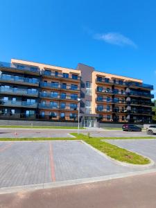 a parking lot in front of a large building at 2 kambarių butas ramioje vietoje in Palanga