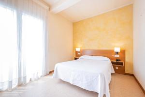 A bed or beds in a room at HOTEL LA PERLA