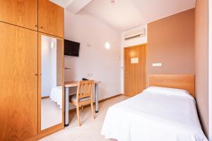 A bed or beds in a room at HOTEL LA PERLA