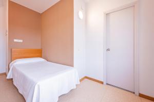 A bed or beds in a room at HOTEL LA PERLA