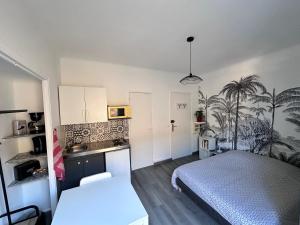 a small bedroom with a bed and a kitchen at Studios climatisés proche mer in Nice