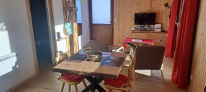 - une salle à manger avec une table et des chaises en bois dans l'établissement Gîte du Faraud, à Saint-Étienne-en-Dévoluy