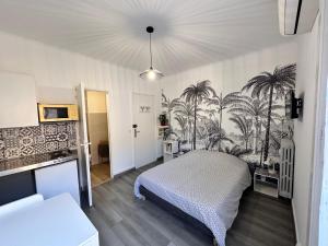 ニースにあるStudios climatisés proche merのベッドルーム1室(ヤシの木の壁にベッド1台付)