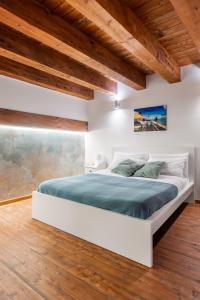 a bedroom with a large white bed with green sheets at Open Sicily Homes - Near the Central Train Station in Palermo