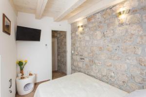 um quarto com uma parede de pedra e uma cama em Apartments Bottega em Dubrovnik