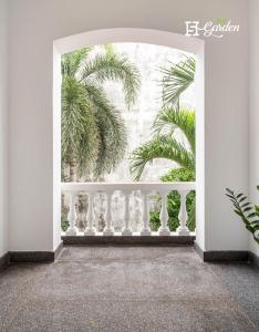 an open door with a balcony with palm trees at 5H Garden in Ho Chi Minh City
