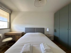 a bedroom with a bed with two towels on it at Le Raphaël - Sur les hauteurs de Bordeaux in Bordeaux