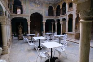 a room with tables and chairs in a building at Vivaana Museum Hotel in Nawalgarh