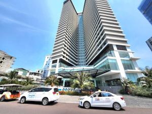 two cars parked in front of a tall building at FLC Sea Tower Quy Nhon - Căn Hộ View Biển in Quy Nhon