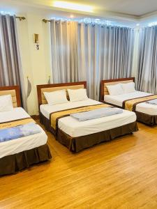 three beds in a room with wooden floors at Hương Sen Hotel Bac Giang in Bắc Giang +23 photos
