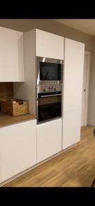 a kitchen with white cabinets and a microwave at Villa Sama’ in Roccaraso