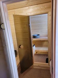 een kleine sauna met een deur in een kamer bij Linte apartment 