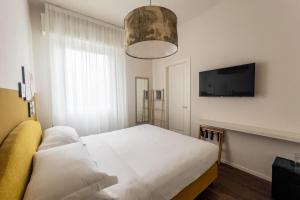 a bedroom with a bed and a flat screen tv at LU BOUTIQUE Hotel in Cervia
