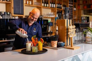 een man die een drankje maakt in een bar bij Summio Parc Port Greve in Brouwershaven