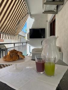 a table with a plate of food and two glasses of juice at CASA al mare MATTIA in Lido di Fermo