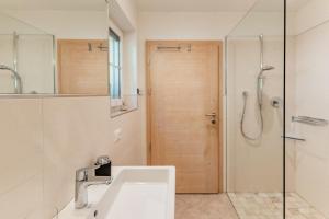a bathroom with a sink and a shower and a mirror at Apartment Niederhaushof in Parcines