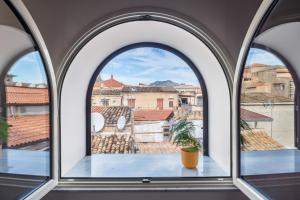 an arched window with a view of the city at Open Sicily Homes "Residence Guascone" - Self check in in Palermo