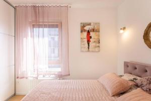 a bedroom with a bed and a picture of a woman with an umbrella at Luxury & Elegance 2BDR Apartment in Zagreb
