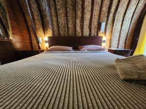 - une chambre avec un grand lit et un mur en bois dans l'établissement Timbis Homestay Bali, à Nusa Dua