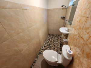 تيمبيس هوم ستاي بالي في نوسا دوا: حمام مع مرحاض ومغسلة