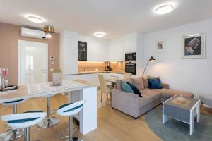 a kitchen and living room with a couch and a table at Luxury & Elegance 2BDR Apartment in Zagreb