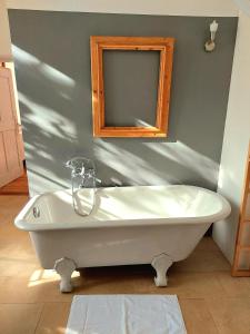 uma banheira branca na casa de banho com um espelho em Stylish Getaway at Austrian Renaissance Castle 