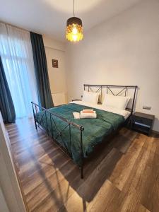 a bedroom with a bed with a green comforter at Apartment in Tbilisi “Green Budapest “ in Tbilisi City