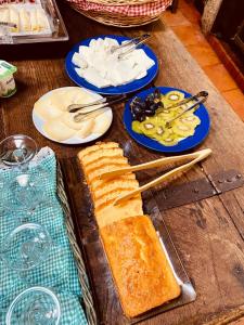 a wooden table with bread and plates of food at Casas Da Ribeira in Seia