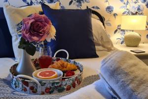 a tray of food on a bed with a vase and flowers at Potter's Retreat by Spires Accommodation an adorably quirky place to stay in Newcastle upon Tyne in Longport