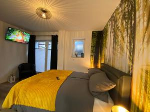 ein Schlafzimmer mit einem Bett mit einer gelben Decke in der Unterkunft Wood II Appartement in Bad Salzuflen