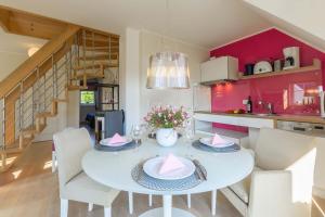 eine Küche und ein Esszimmer mit einem weißen Tisch und Stühlen in der Unterkunft Mönchgut - Strand Resort Rex Rugia App 05 in Lobbe + 9 Fotos