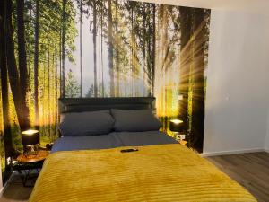 ein Schlafzimmer mit einem Bett und einem Wandbild aus dem Wald in der Unterkunft Wood II Appartement in Bad Salzuflen