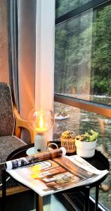 a table with a candle on a table with a window at River Side TinyHouse in Çamlıhemşin