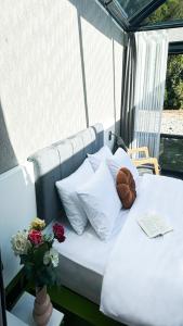 a white bed with pillows and flowers on a porch at River Side TinyHouse in Çamlıhemşin