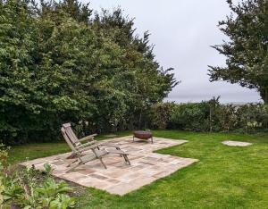 The Lookout: Cosy Compact Cottage في Totland: مقعد وطاولة في الفناء