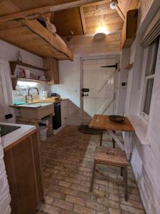 a kitchen with a table and a sink in a room at The Lookout: Cosy Compact Cottage in Totland