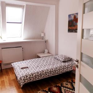 - une petite chambre avec un lit et une fenêtre dans l'établissement Apart Lwowska, à Varsovie