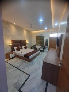 a bedroom with a bed and a living room at The highclass hotel in Bathinda