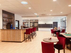 a restaurant with a bar and tables and chairs at Résidence Services Séniors in Montignac