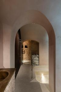 ein Torbogen, der zu einem Bad mit einem Waschbecken führt in der Unterkunft No Church Inside in Trani