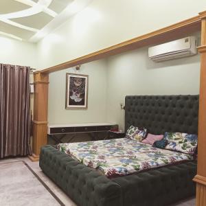 a bed in a room with a black bed frame at White Lotus Karachi in Karachi