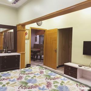 a bedroom with a bed and a television in it at White Lotus Karachi in Karachi