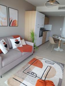 a living room with a couch and a kitchen at Appartement standing vue étang de Thau in Marseillan