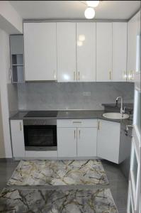 a kitchen with white cabinets and a sink at Apartment Ilidza-SK 2 in Sarajevo